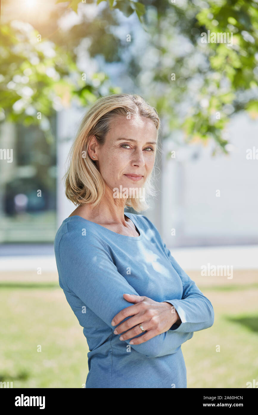 Portrait of confident blond woman in a park Stock Photo