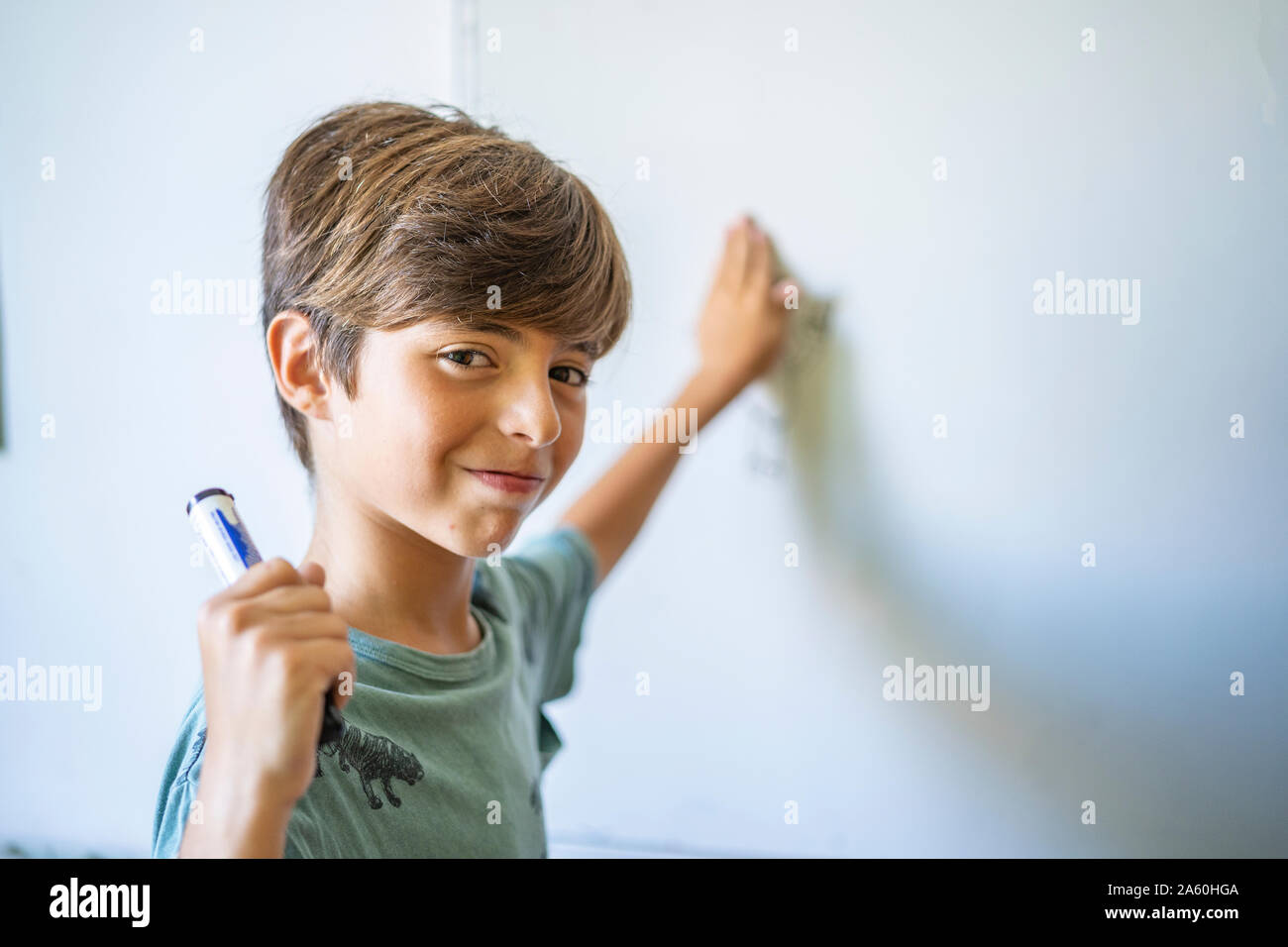 Portrait of confident boy in front of a whiteboard Stock Photo