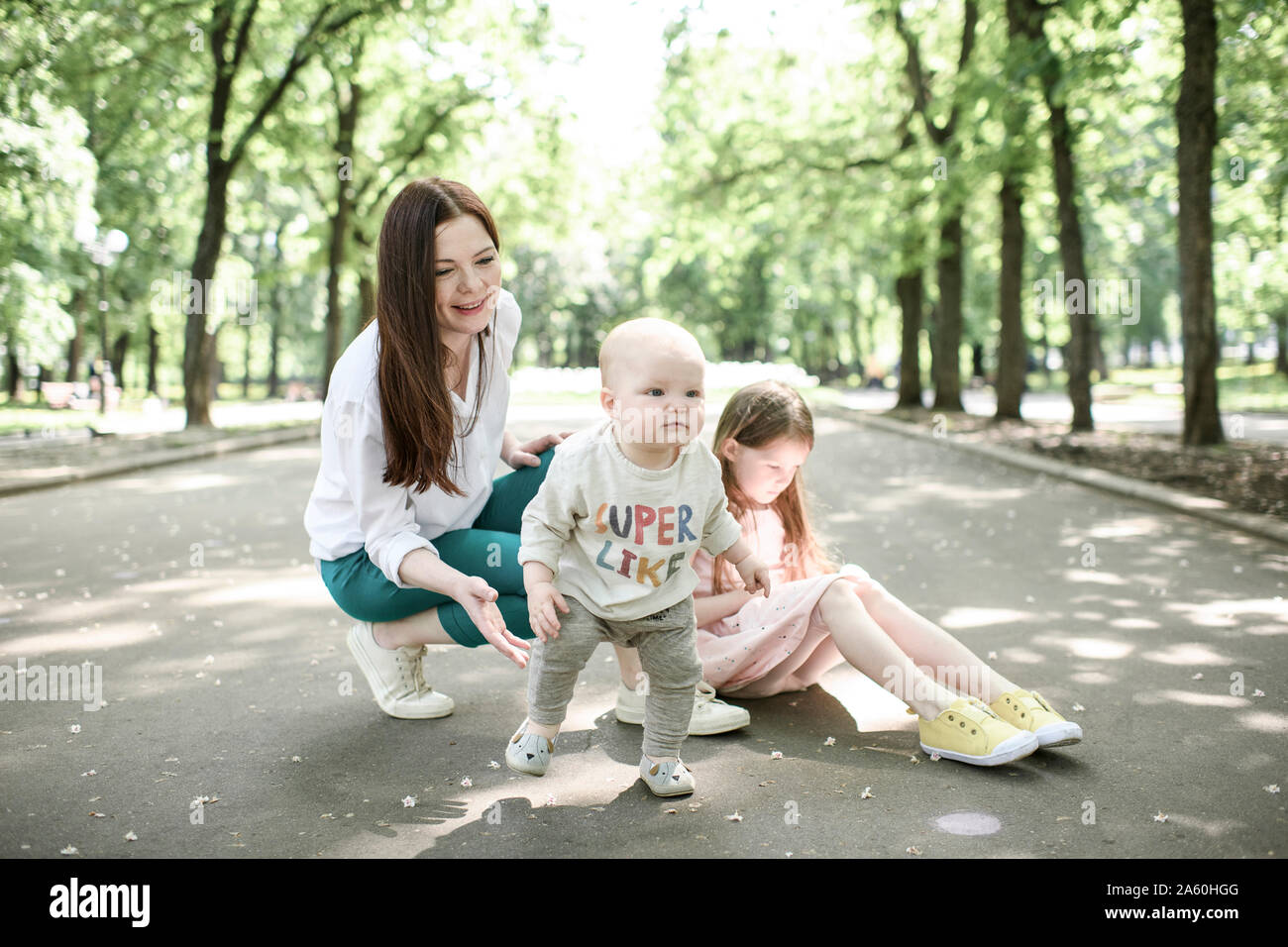 Smiling mother with her two kids in the park Stock Photo