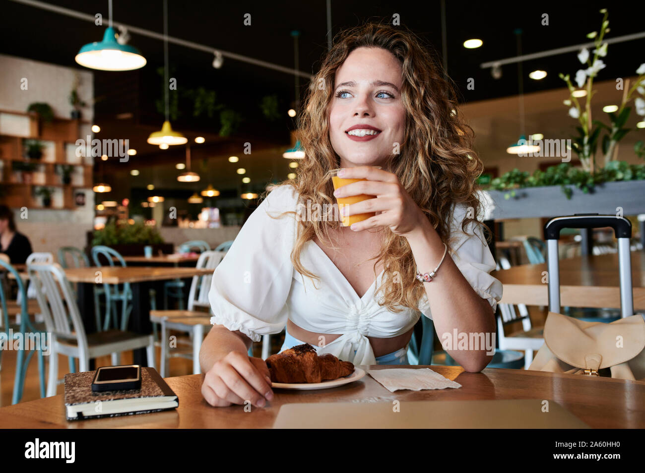 Smiling young woman in a cafe having breakfast Stock Photo