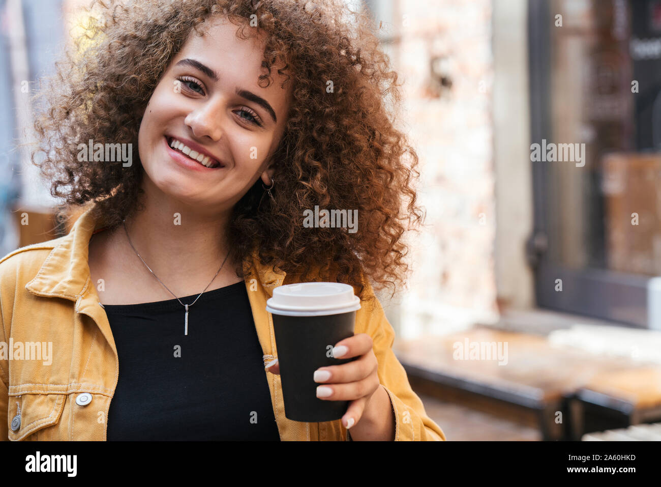 Portrait of happy teenage girl with coffee to go Stock Photo