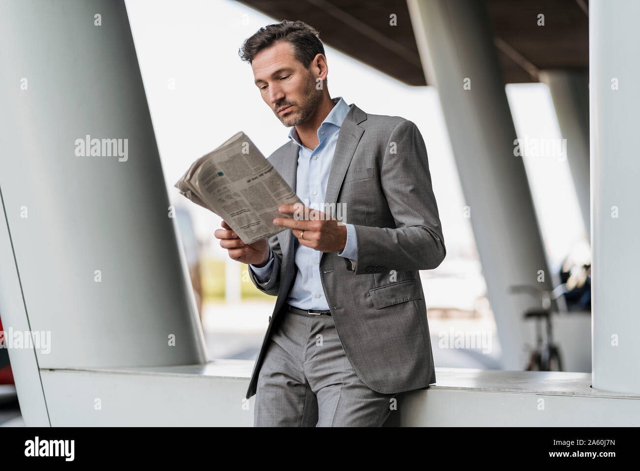 Portrait of businessman reading newspaper outdoors Stock Photo