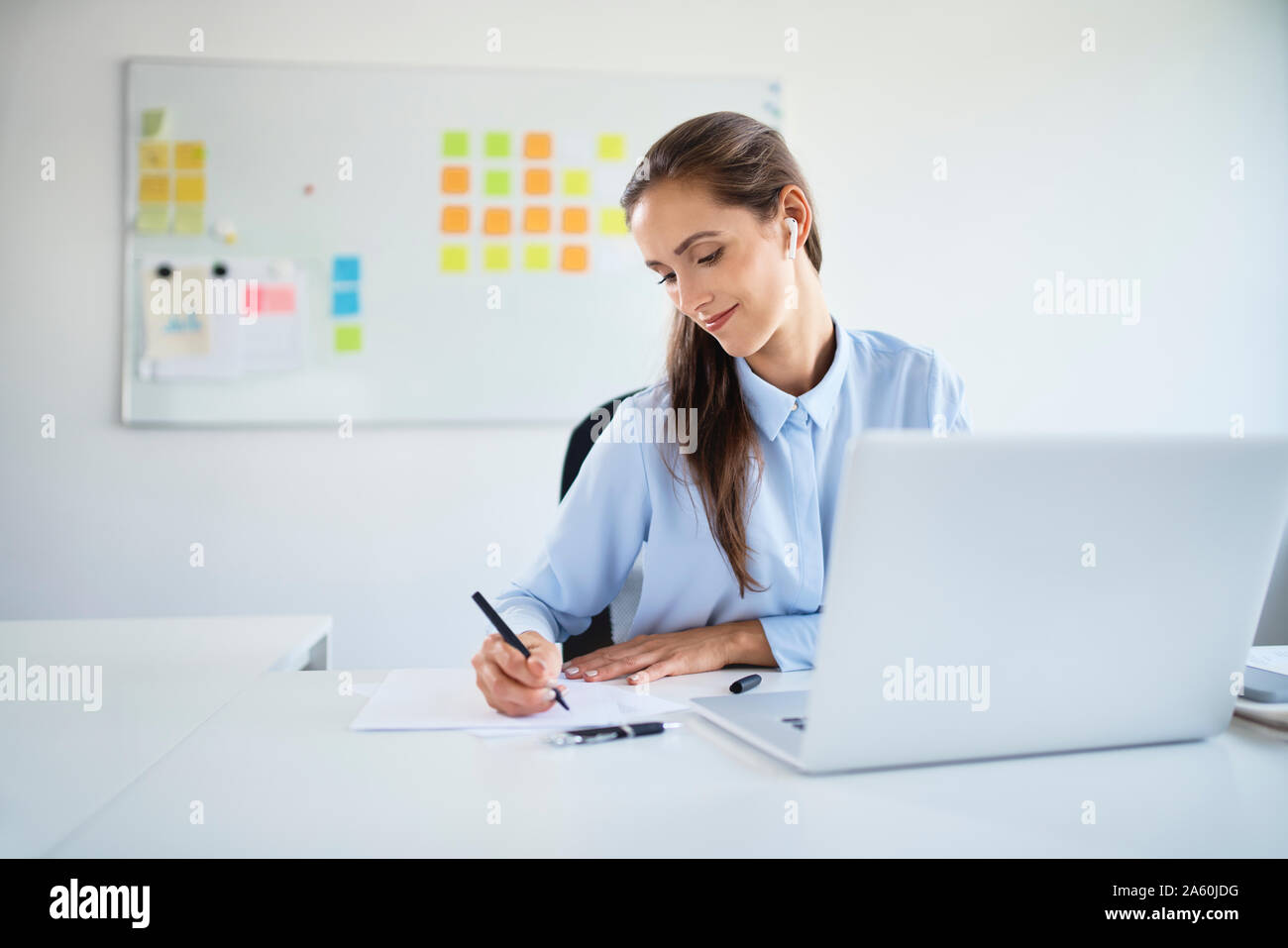 Young businesswoman preparing business documents while working with laptop in office Stock Photo
