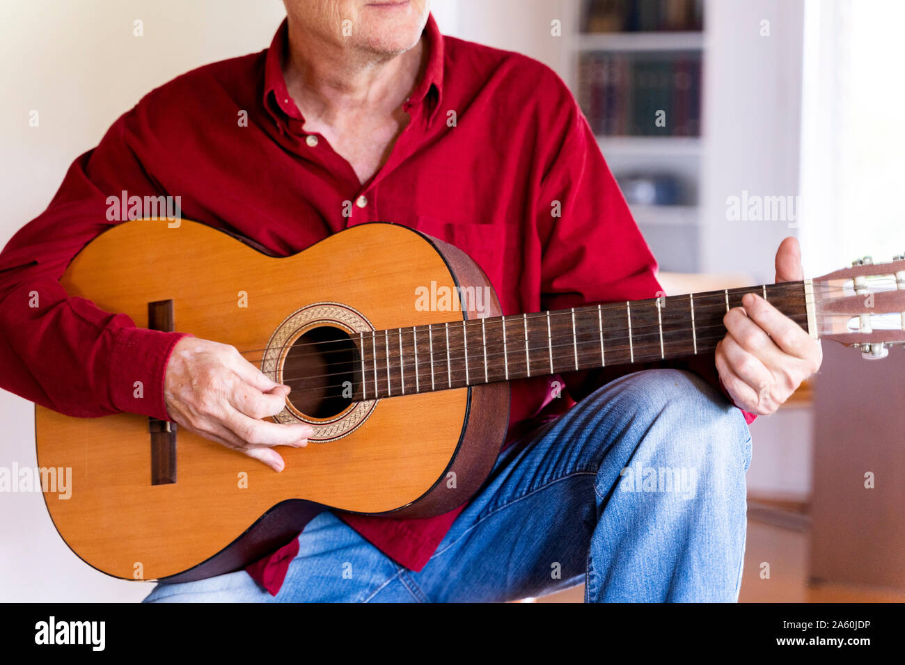 Senior man playing guitar at home Stock Photo