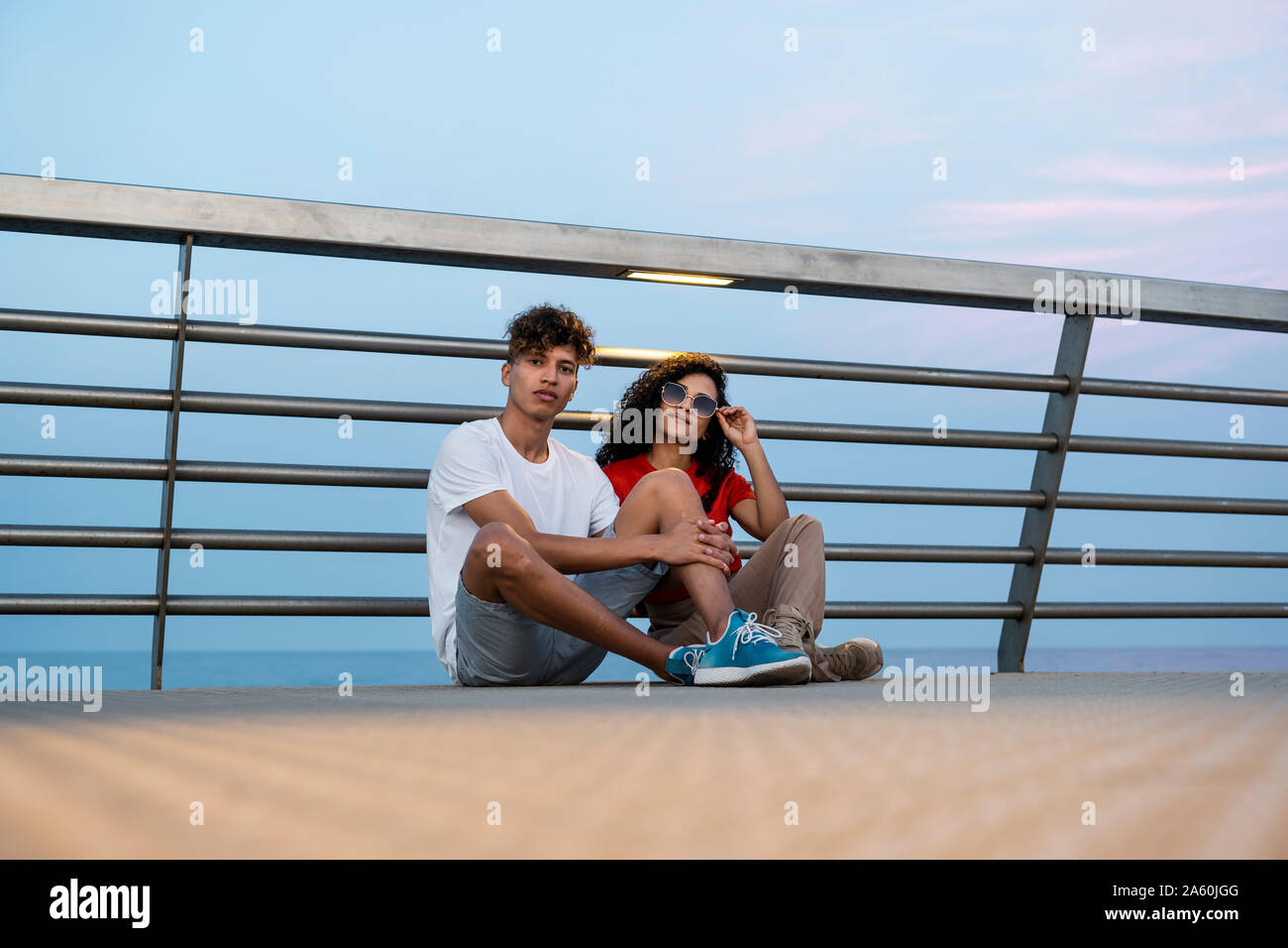 Two women sitting on bridge hi-res stock photography and images - Alamy