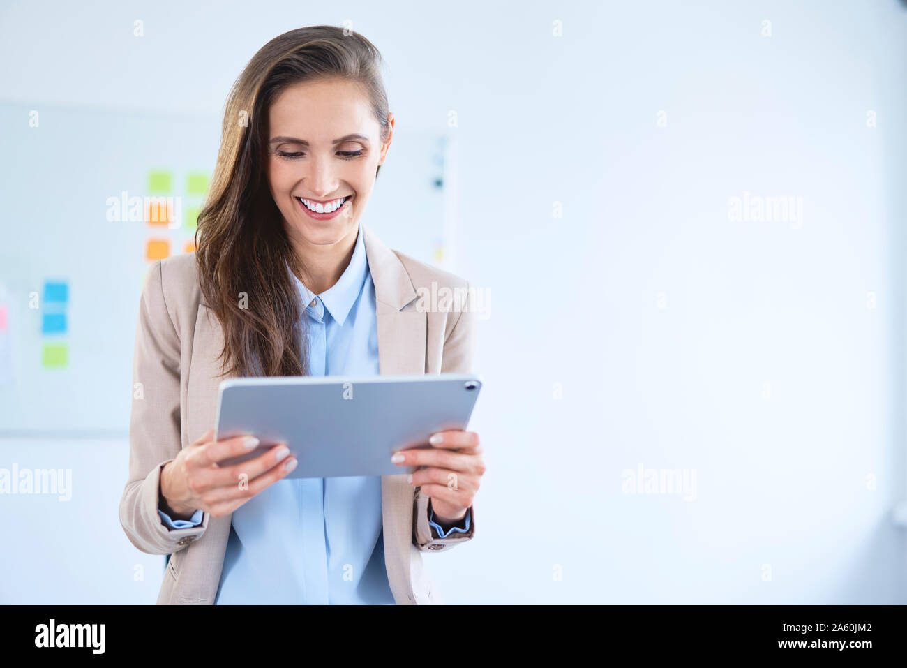 Smiling businesswoman using tablet in office Stock Photo