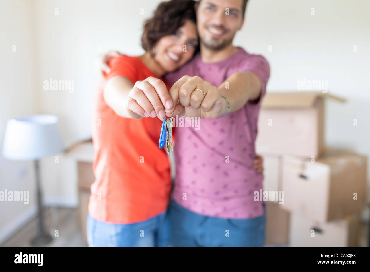 Happy couple showing the keys of the new home Stock Photo - Alamy