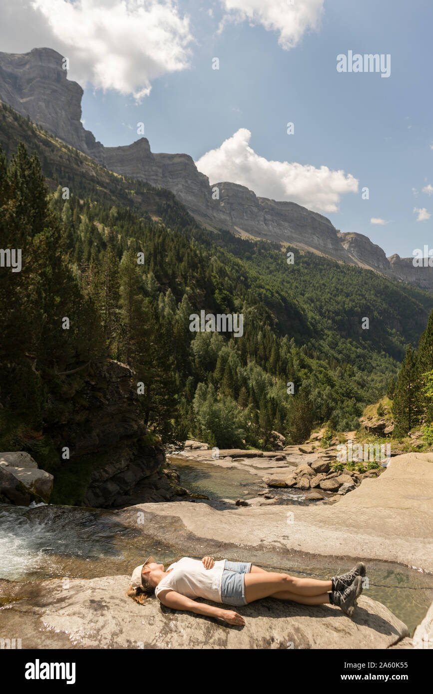 Woman lying on a rock in the mountains hires stock photography and