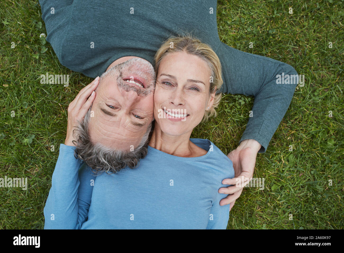 Top view of happy mature couple lying in grass Stock Photo
