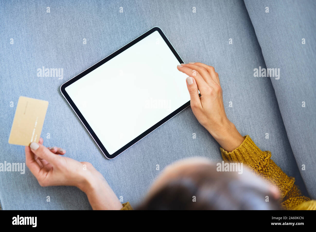 Overhead view of woman using tablet and credit card to buy online from home Stock Photo