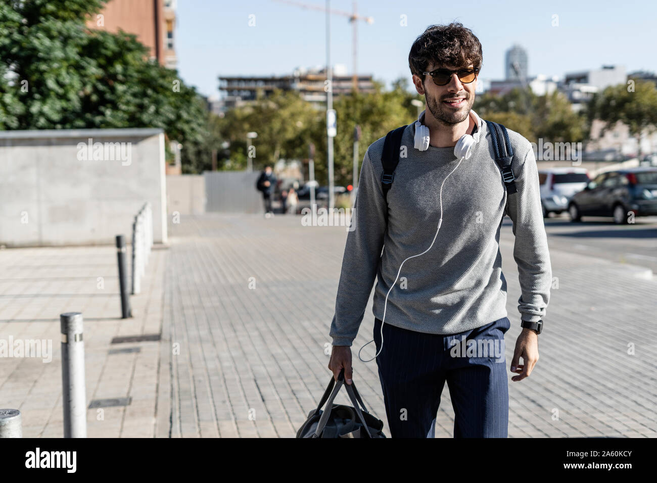 Man with travelling bag in the city on the go Stock Photo