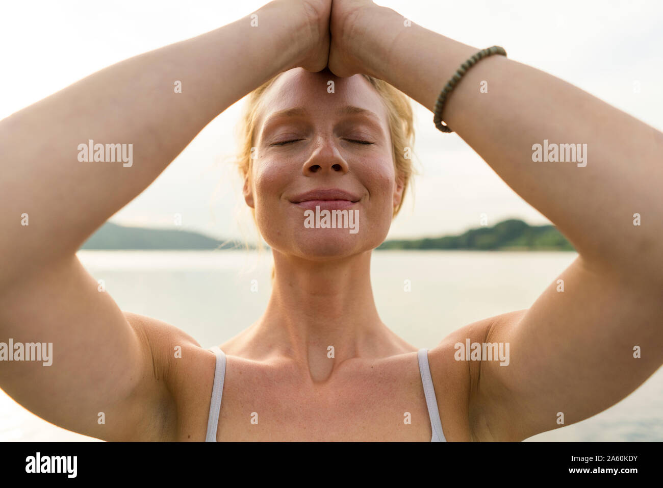 Portrait of young woman with closed eyes at a lake Stock Photo