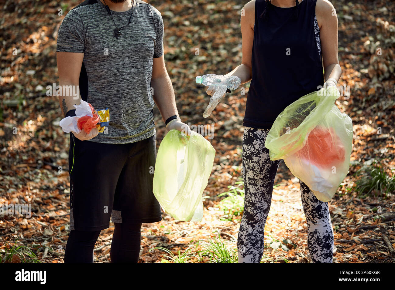 Couple plogging in forest Stock Photo - Alamy