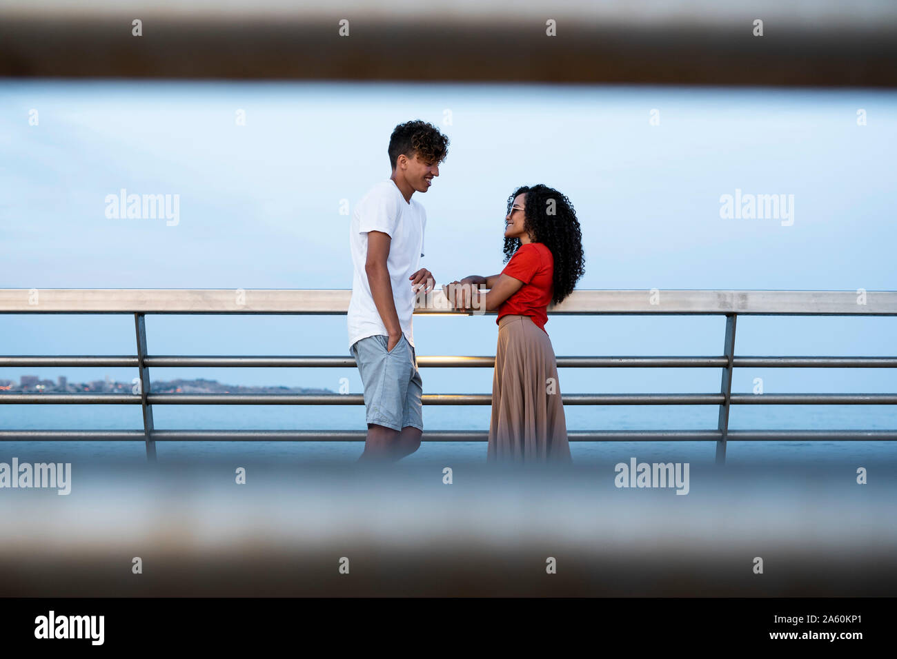 Flirting couple standing on bridge, talking Stock Photo