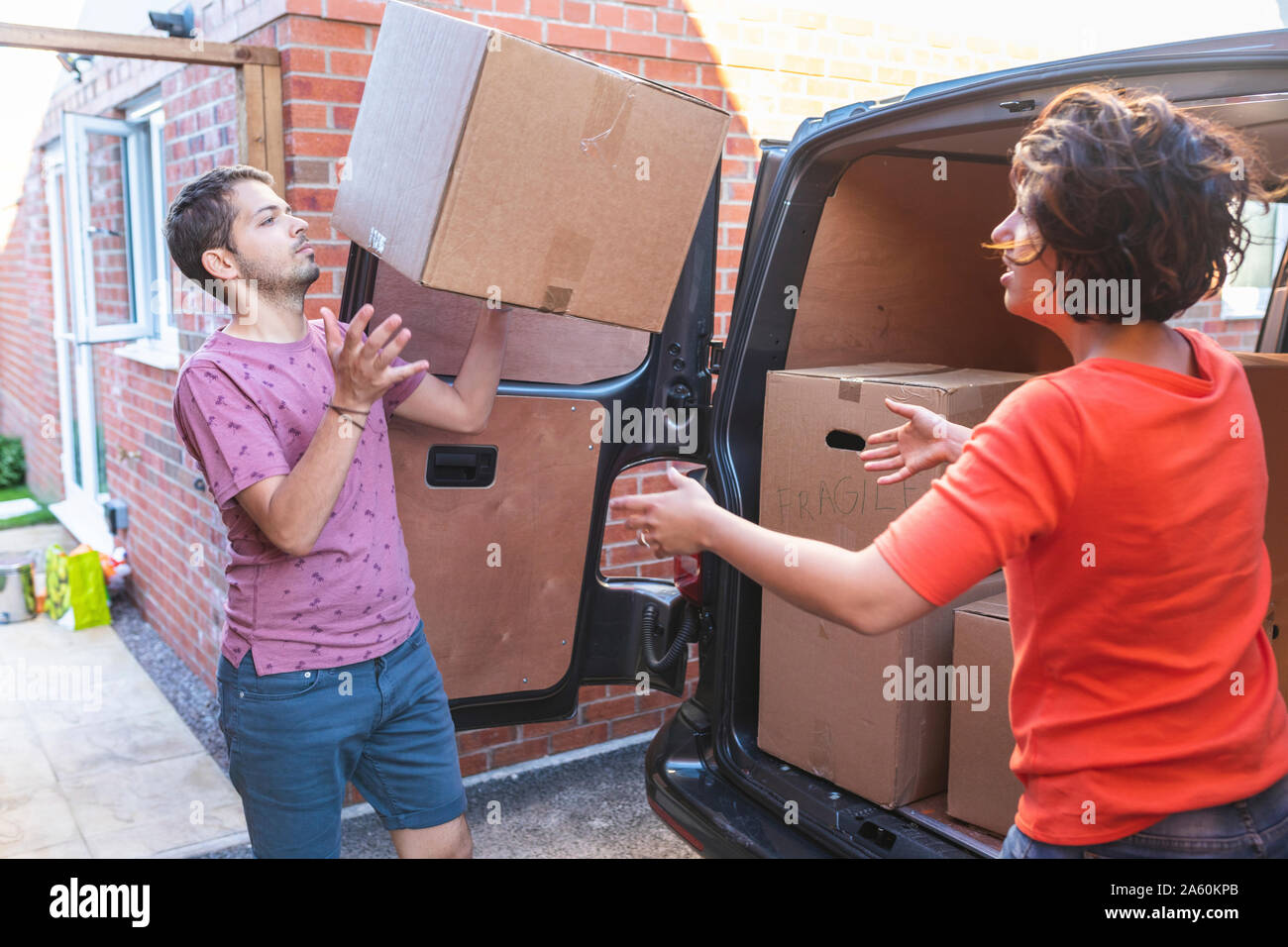 Couple unloading cardboard boxes from van Stock Photo