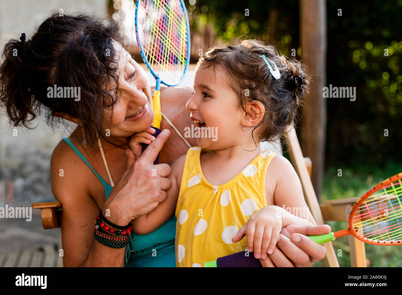 Grandmother playing with little girl and badminton rackets outdoors Stock Photo