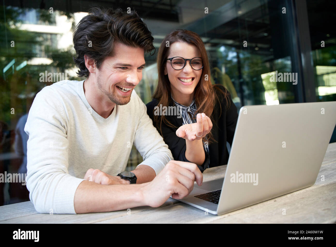 Businessman and happy businesswoman with laptop meeting in the city Stock Photo