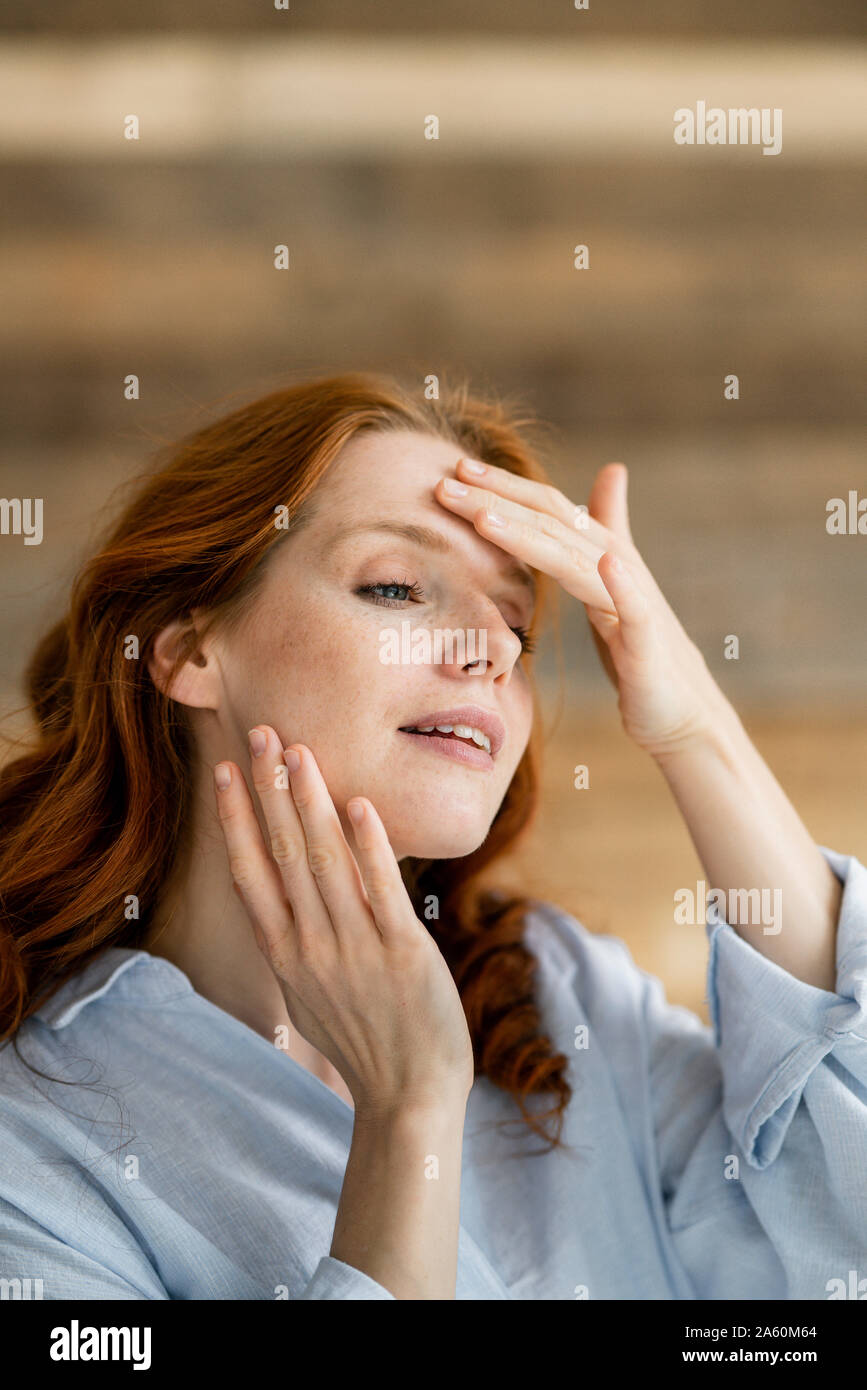 Portrait of redheaded woman touching her face Stock Photo