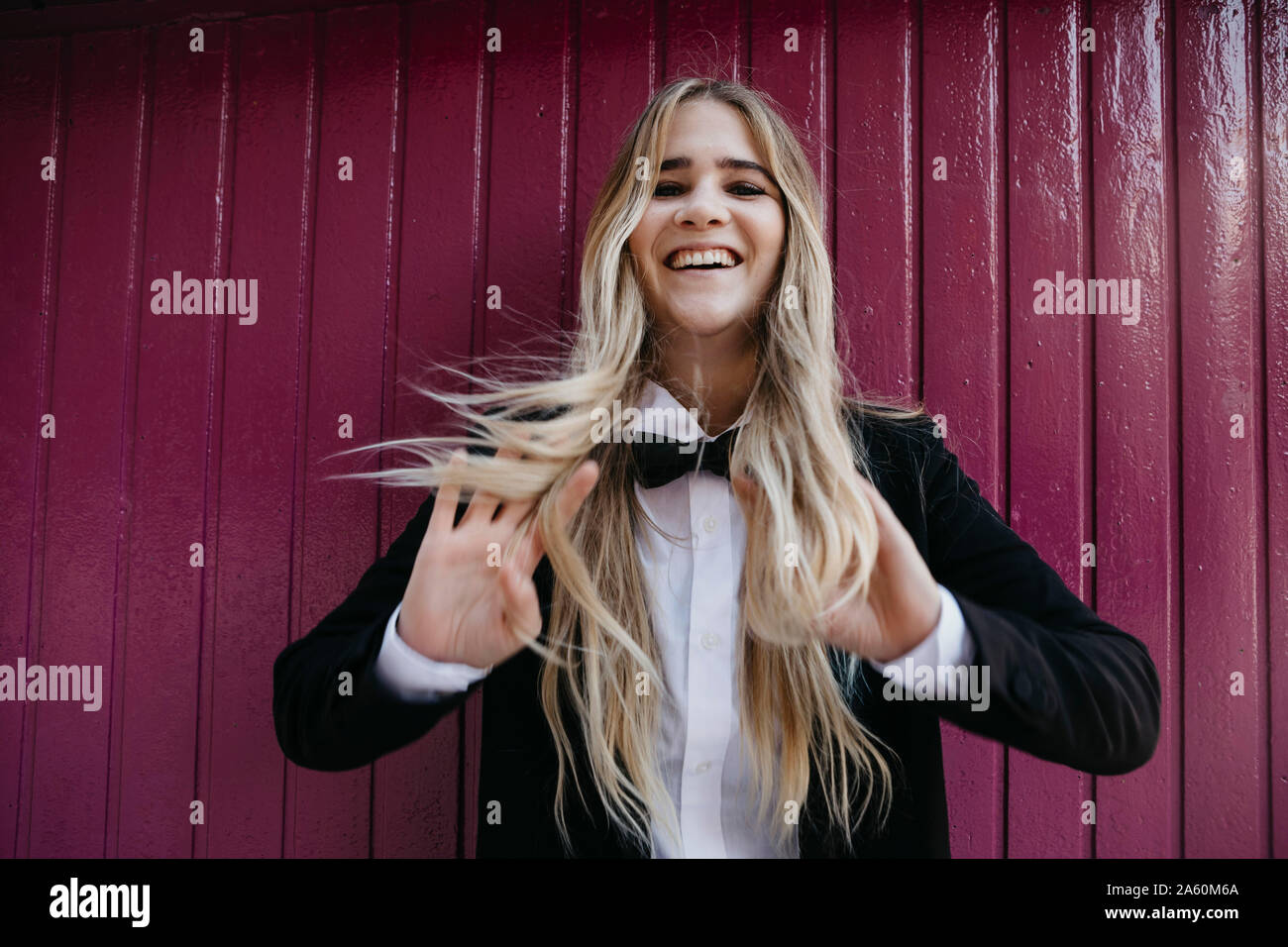 Portrait of laughing blond woman wearing black tie and blazer Stock Photo