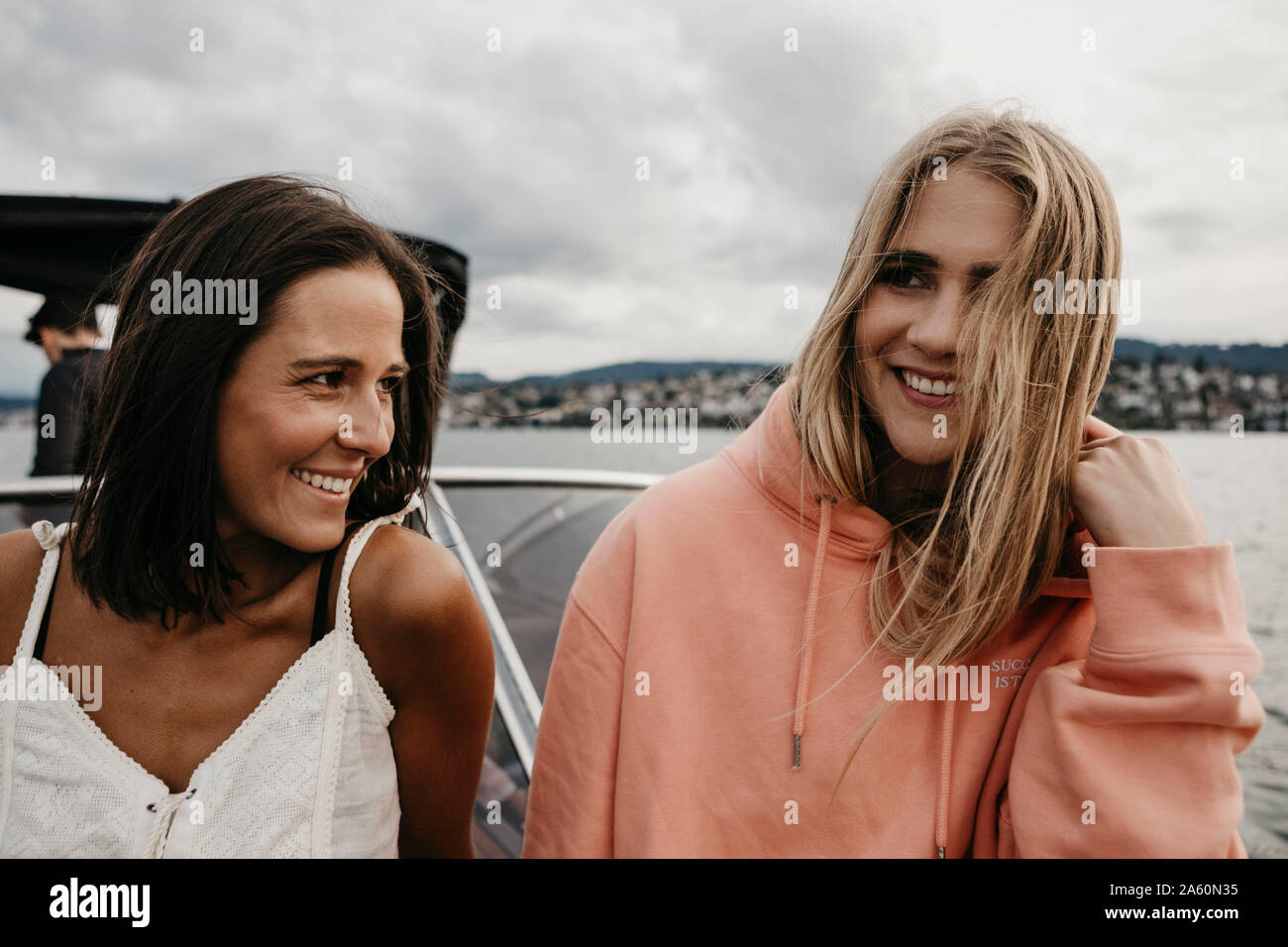 Happy female friends on a boat trip on a lake Stock Photo