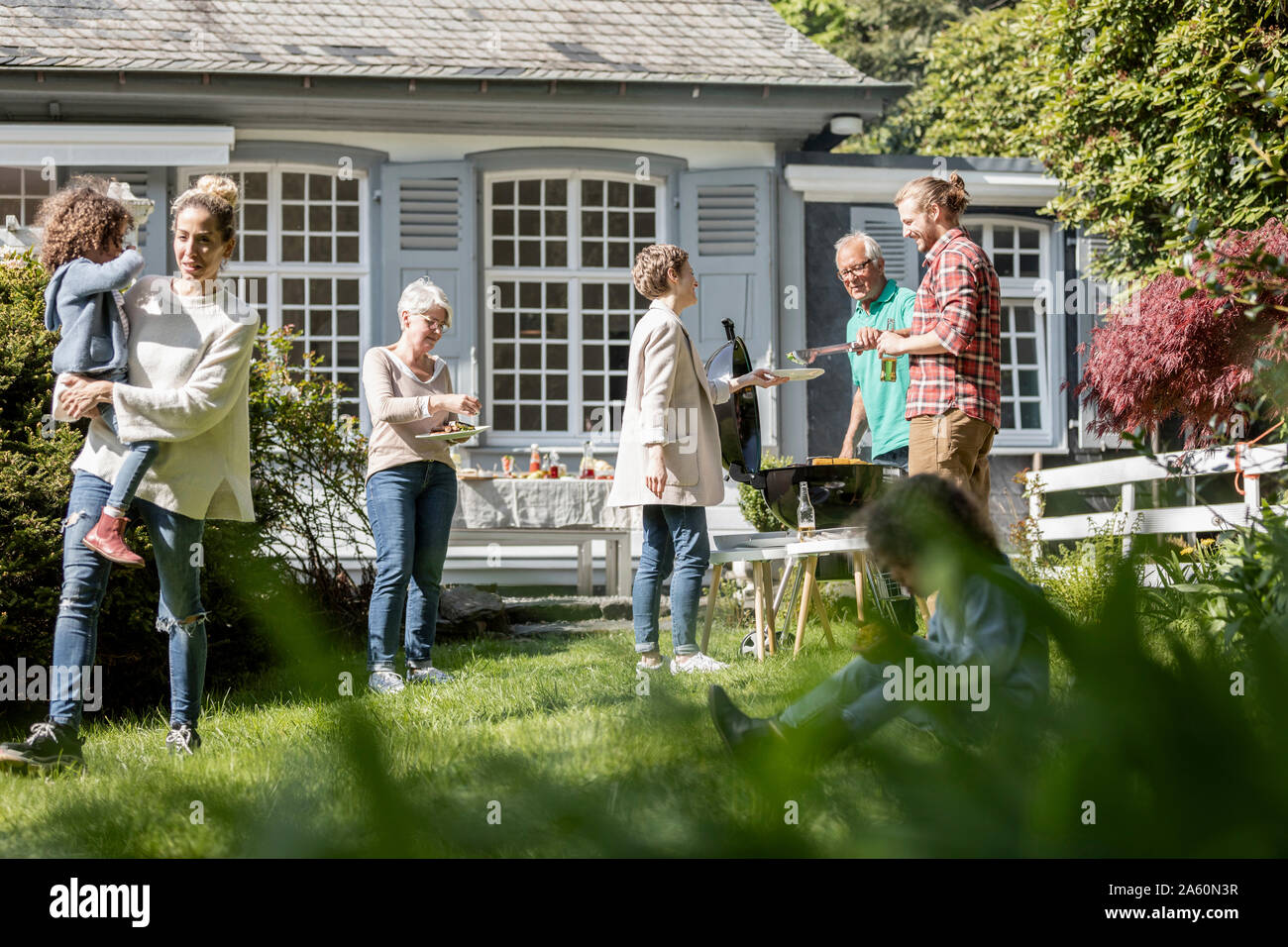 Extended family having a barbecue in garden Stock Photo