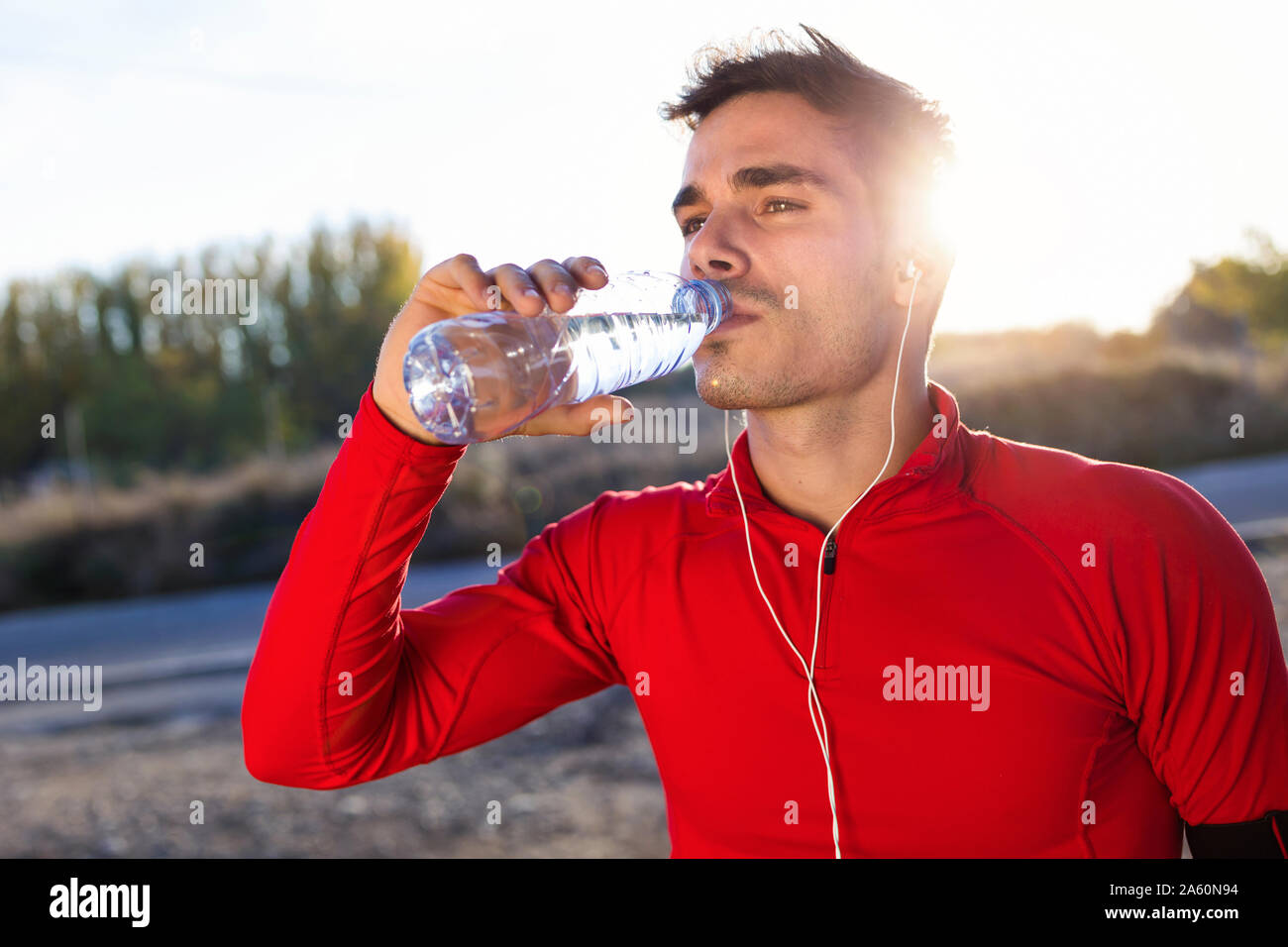 Young jogger drinking from a water bottle Stock Photo