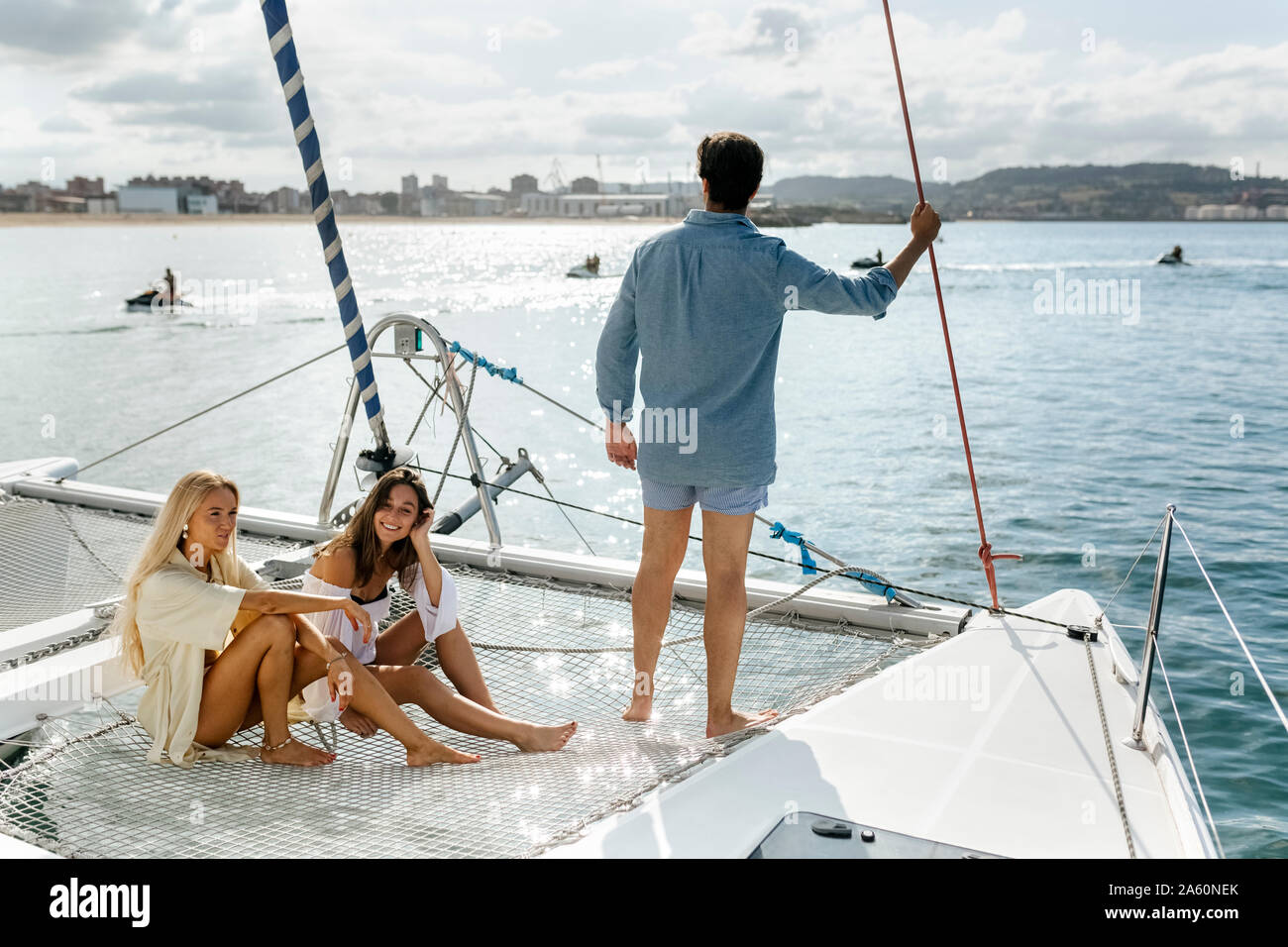 Three young friends enjoying a summer day on a sailboat Stock Photo