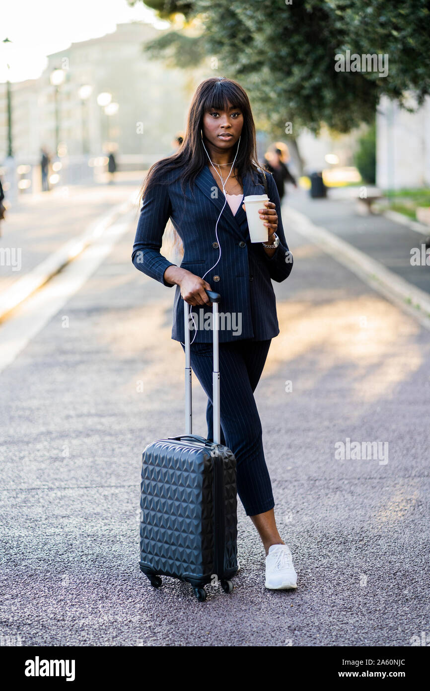Portrait of a businesswoman with suitcase and coffe to go outdoors Stock Photo