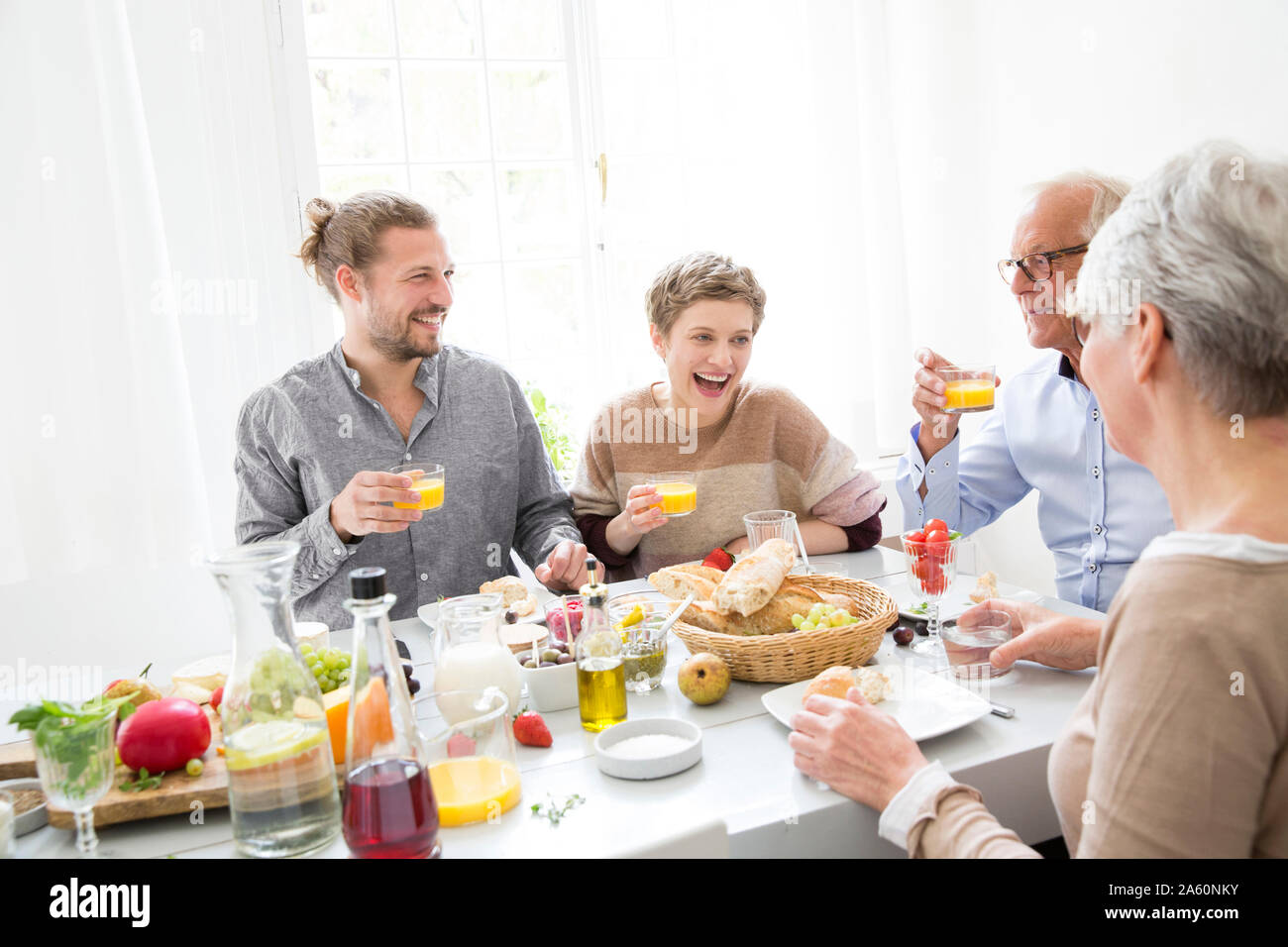 Happy senior couple with adult children having lunch at home Stock Photo