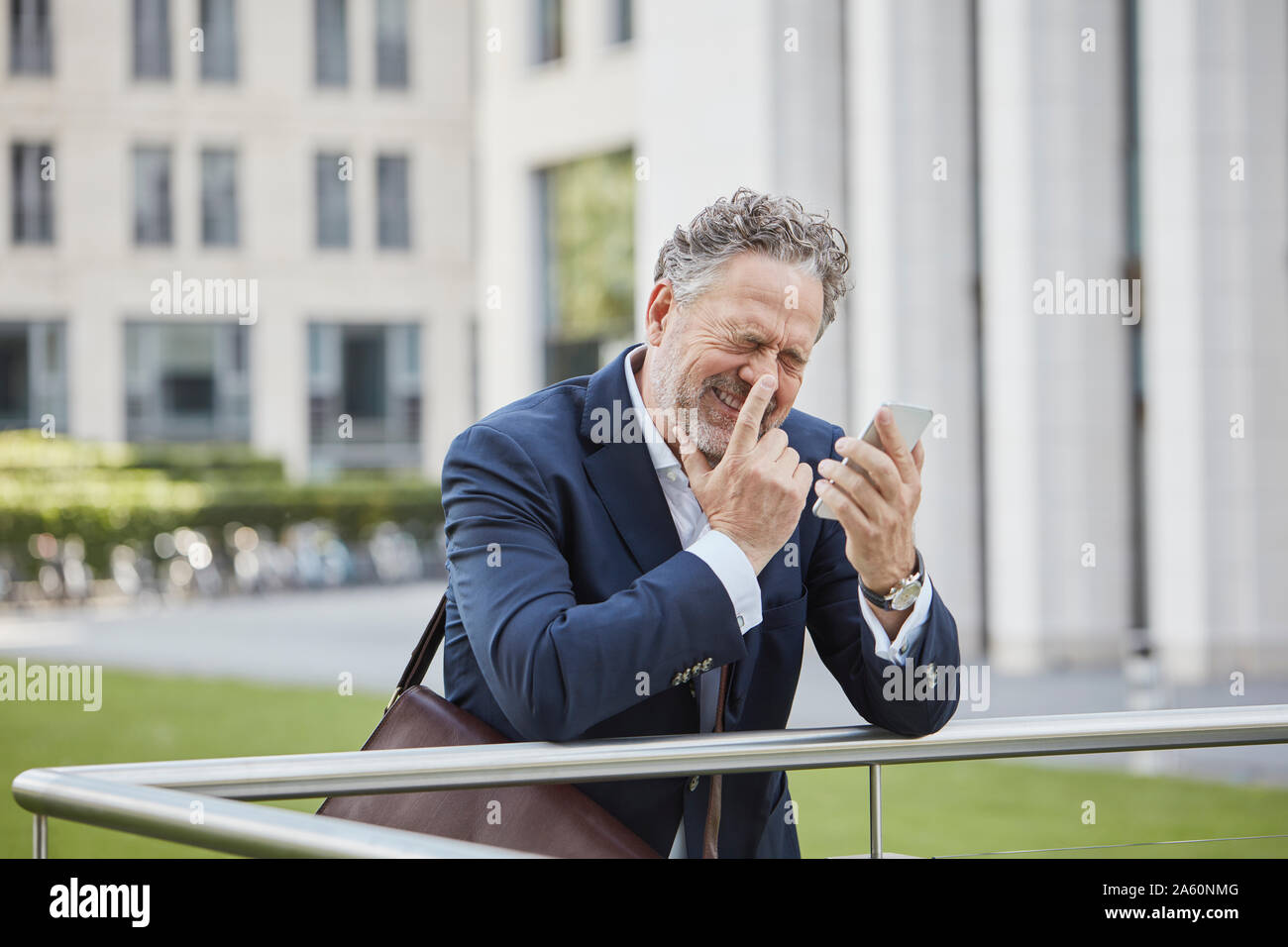 Happy mature businessman with smartphone in the city Stock Photo