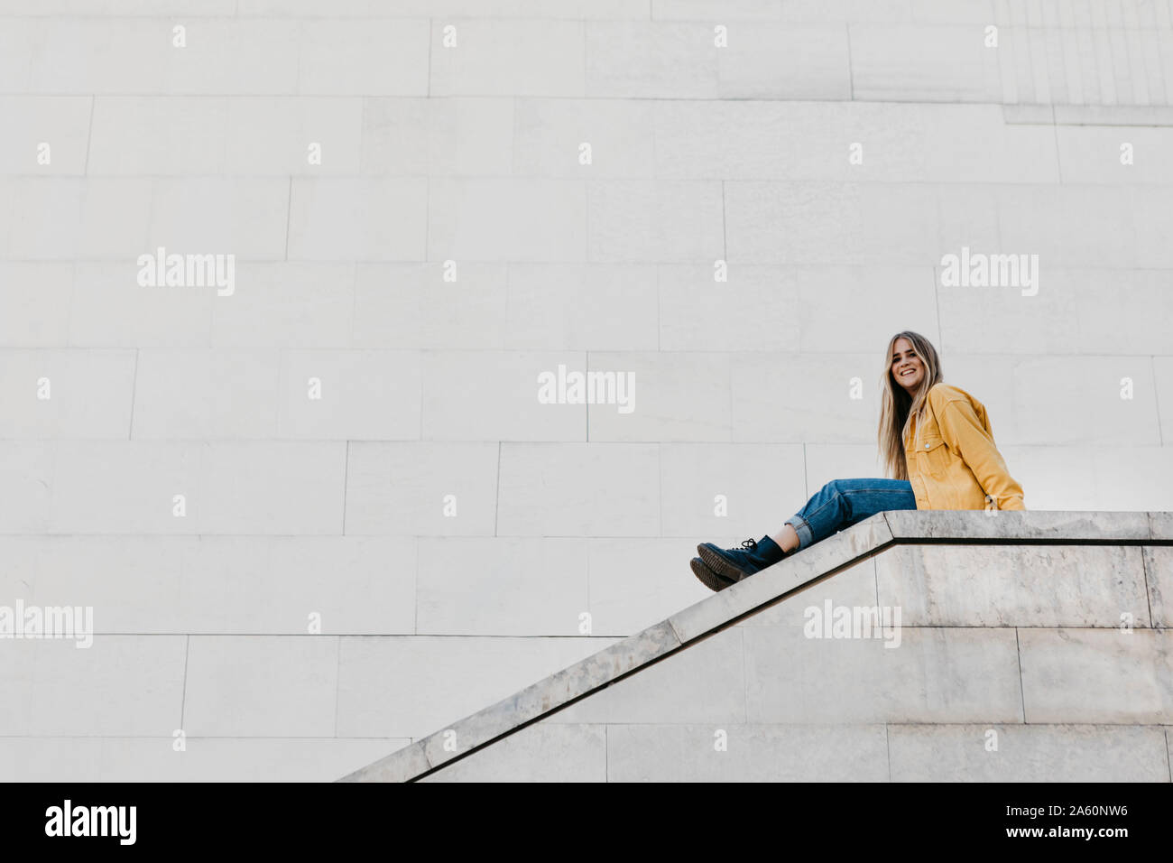 Woman sitting wall relaxed hi-res stock photography and images - Alamy