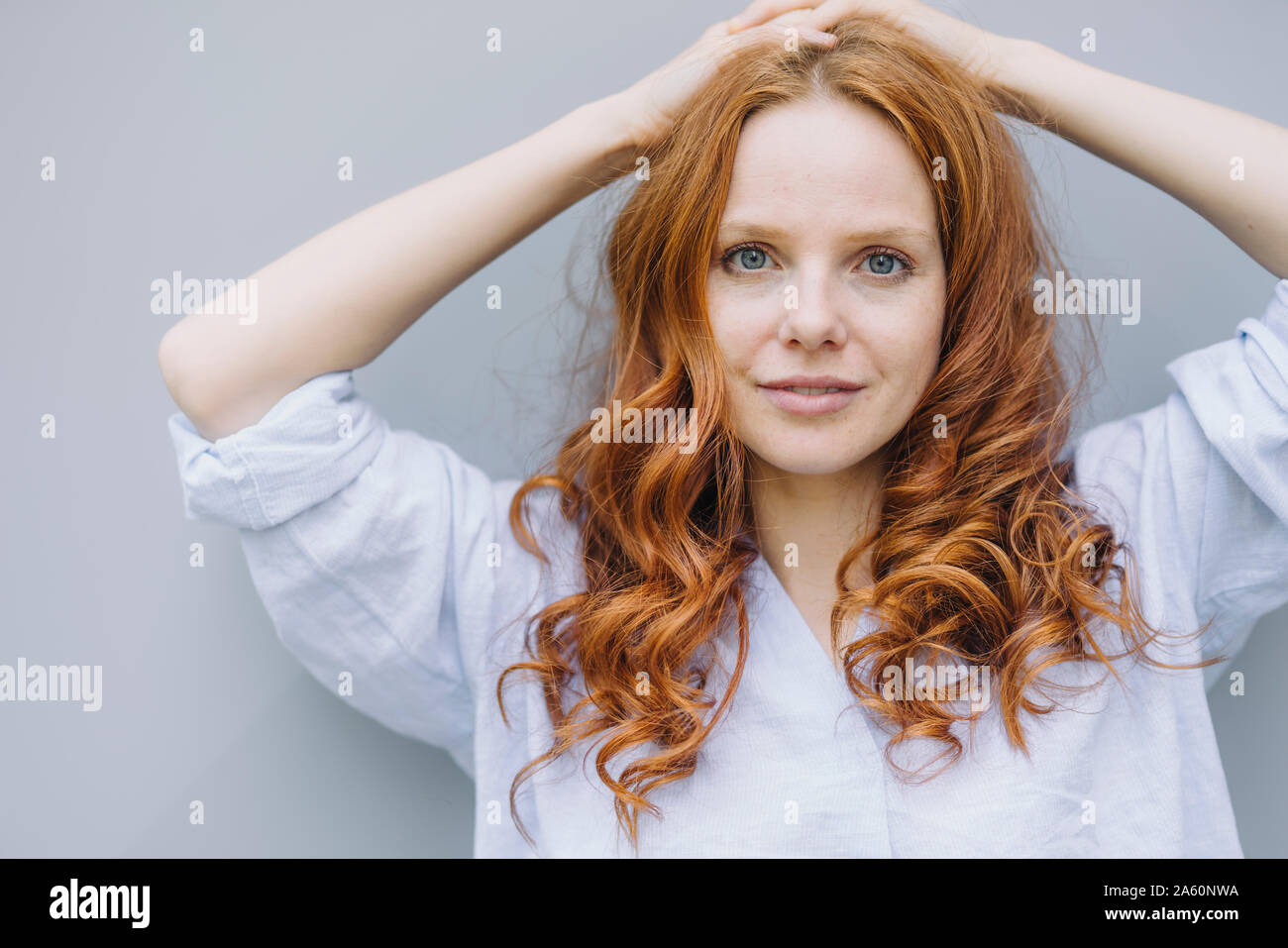 Portrait of beautiful redheaded woman at a wall Stock Photo - Alamy