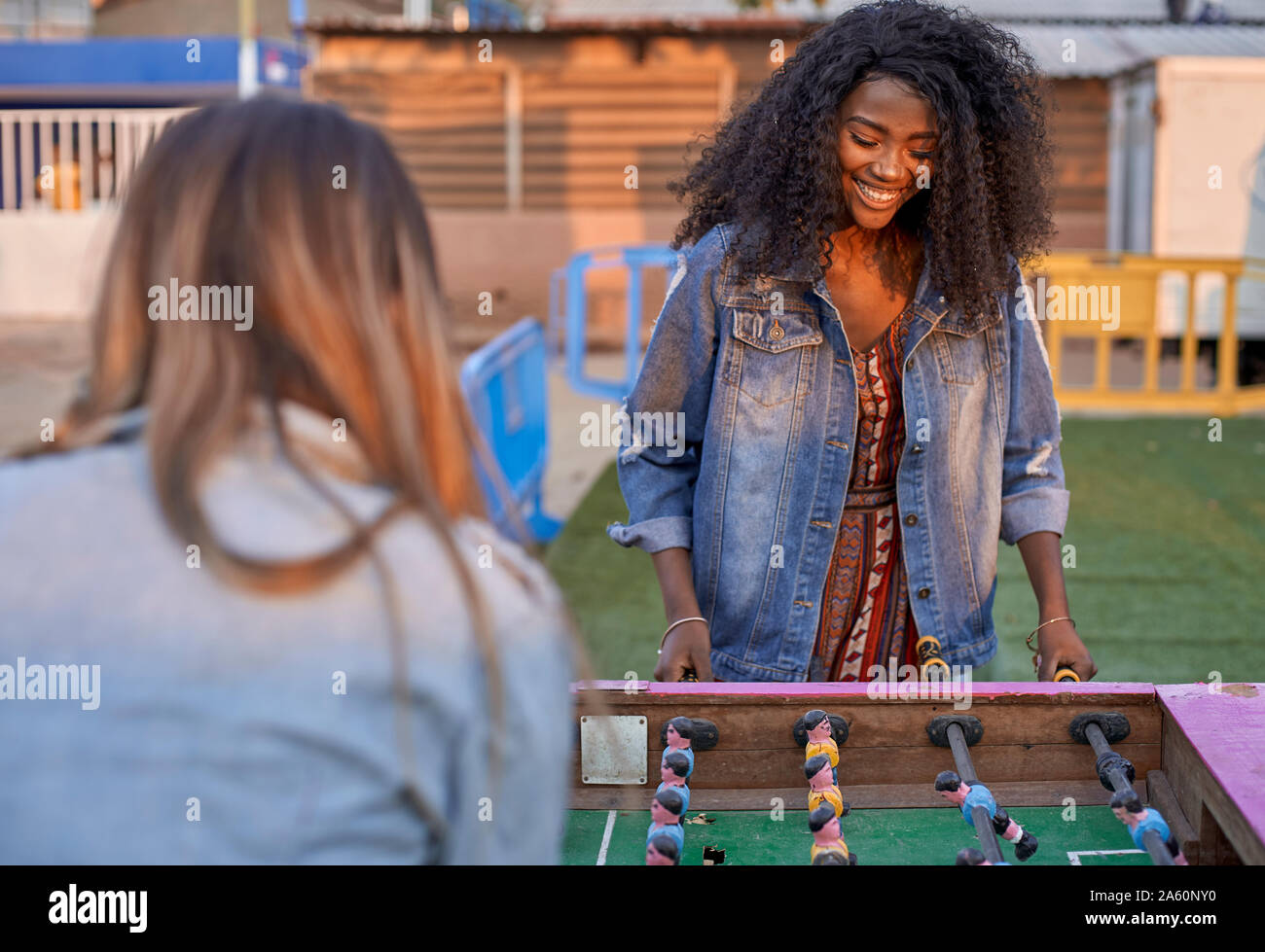 Portrait of happy young woman playing table football with her friend Stock Photo