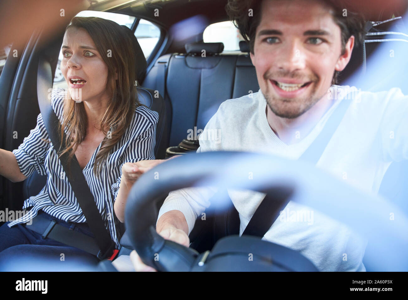 Shocked couple in a car with man driving Stock Photo