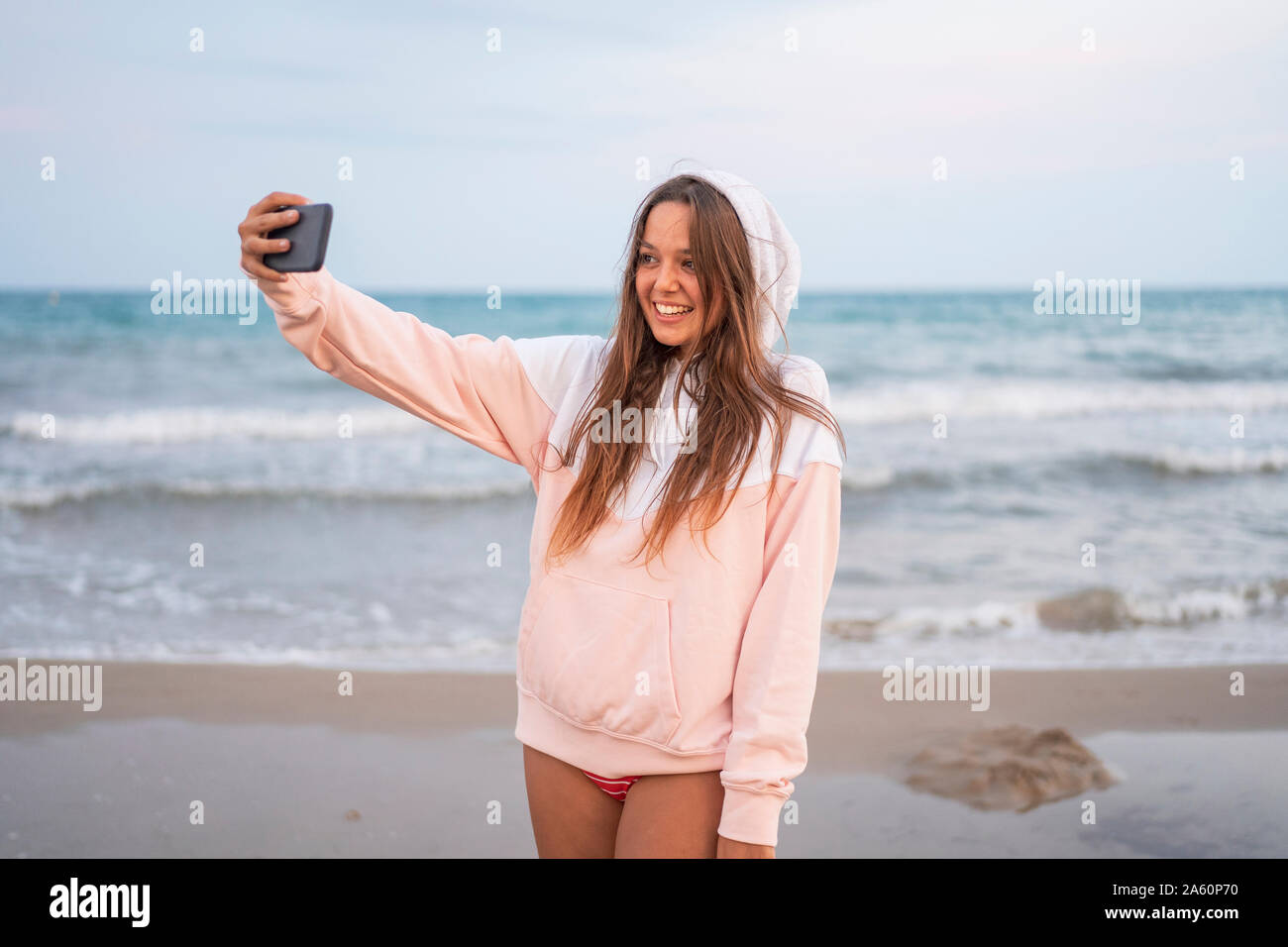 Happy young woman taking a selfie on the beach Stock Photo - Alamy