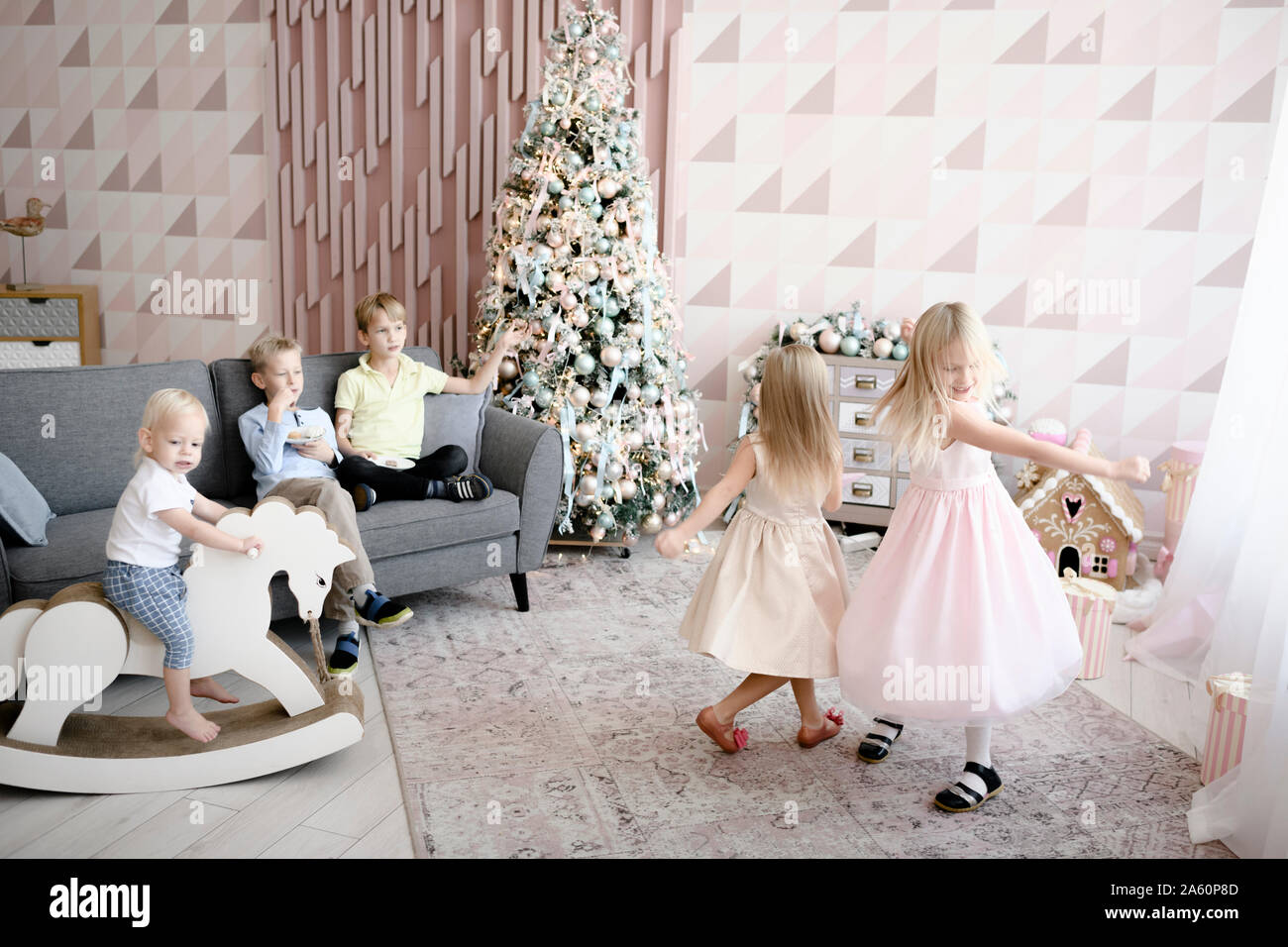 Two girls dancing in the living room while the boys watching them Stock Photo