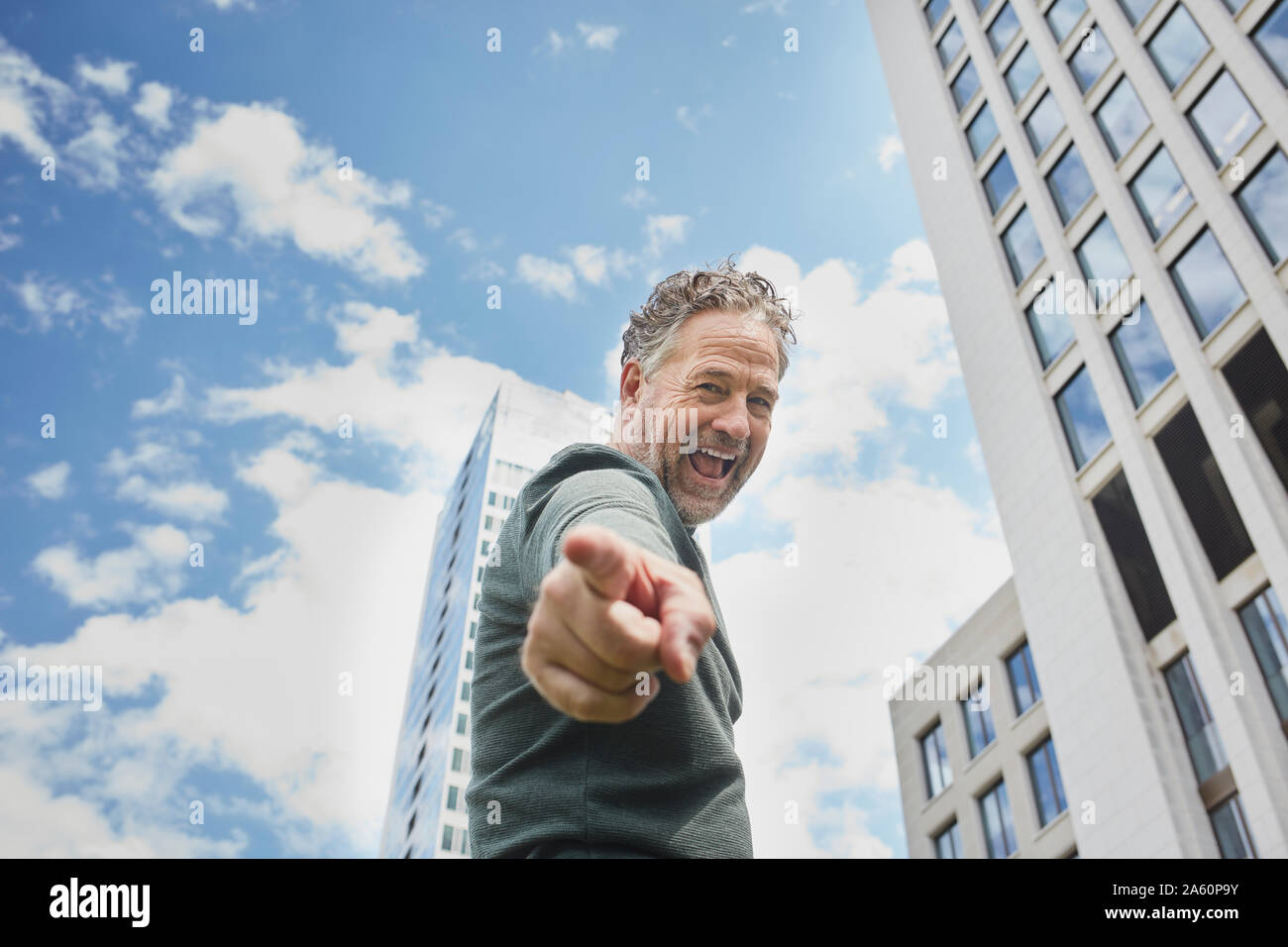 Portrait of mature man in the city screaming and pointing his finger Stock Photo