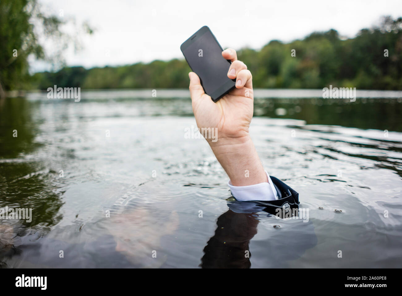 View of Businessman's hand holding cell phone inside a lake Stock Photo - Alamy