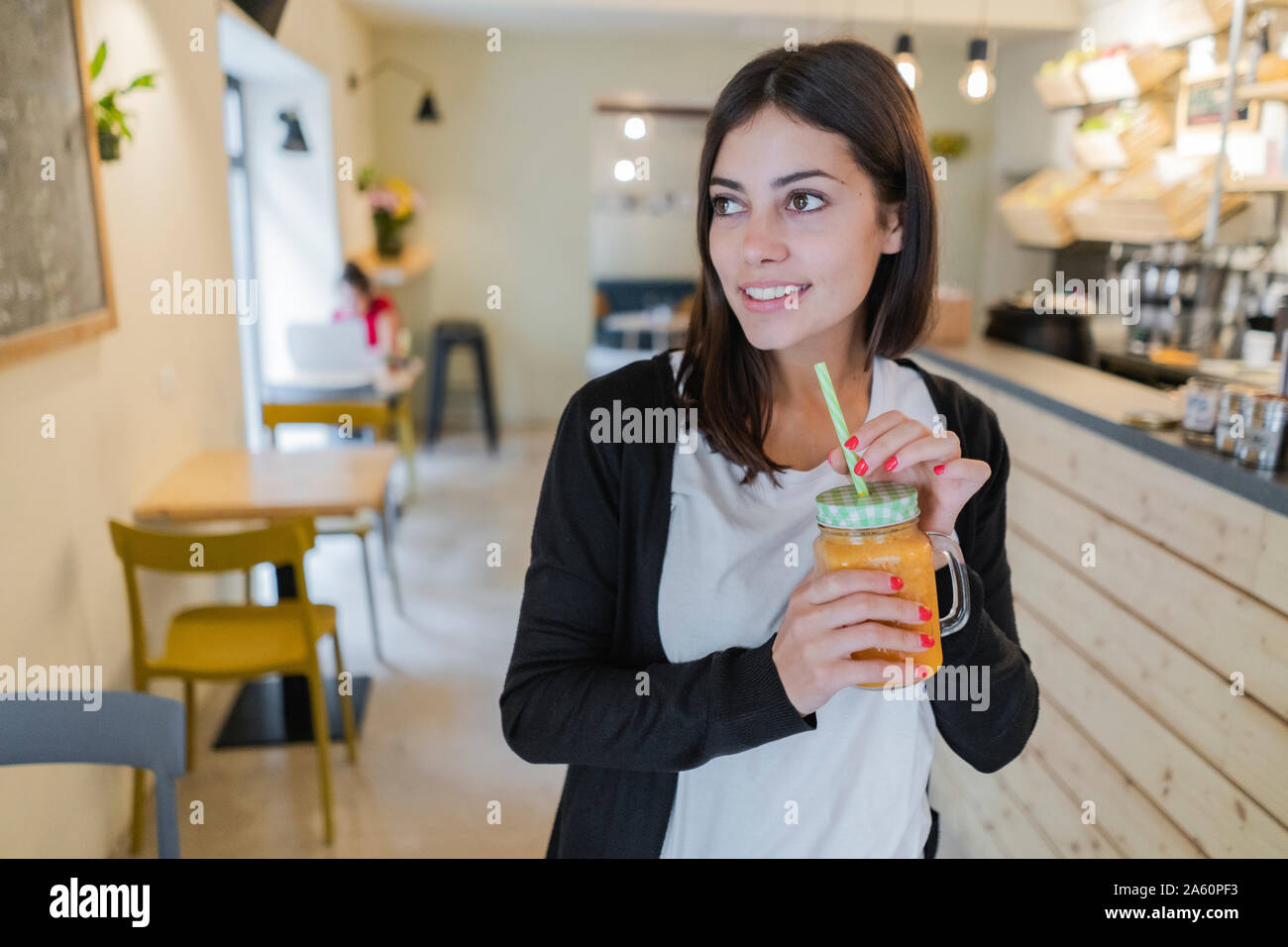 Portrait of a young woman with a smoothie in a cafe Stock Photo