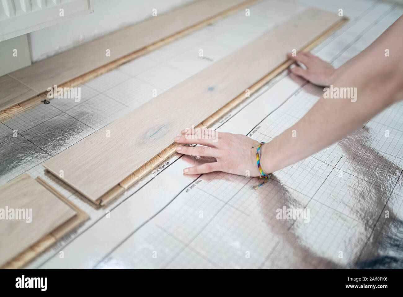 Woman laying footstep sound insulation, partial view Stock Photo