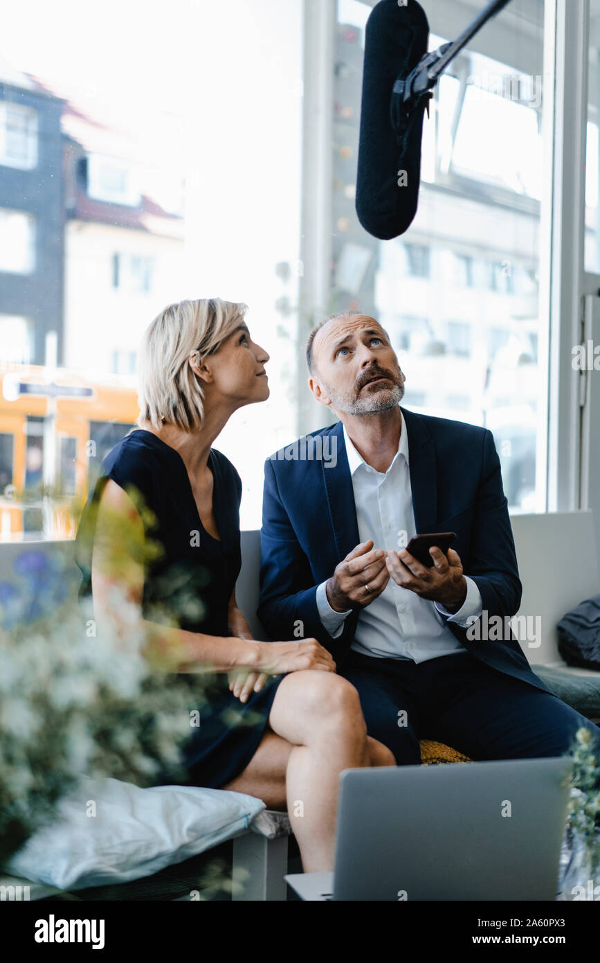 Microphone listening to businesswoman an d man , using smartphone Stock Photo