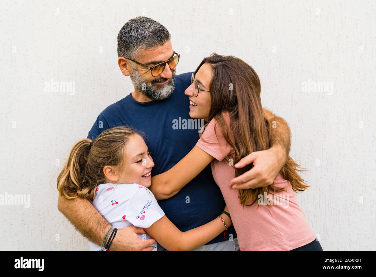 Father hugging two daughters outdoors Stock Photo