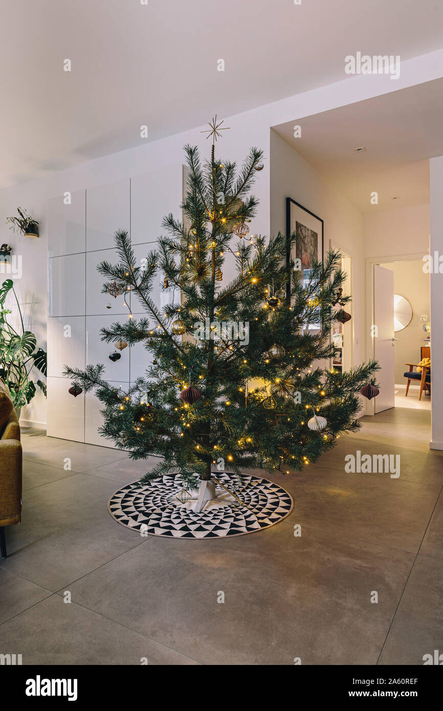 Decorated pine Christmas tree in living room Stock Photo