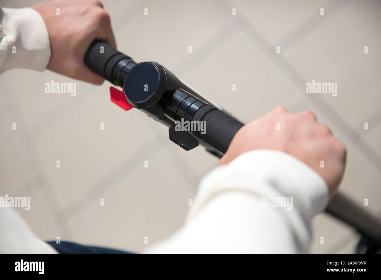 Close-up of hands on handlebar of an e-scooter Stock Photo