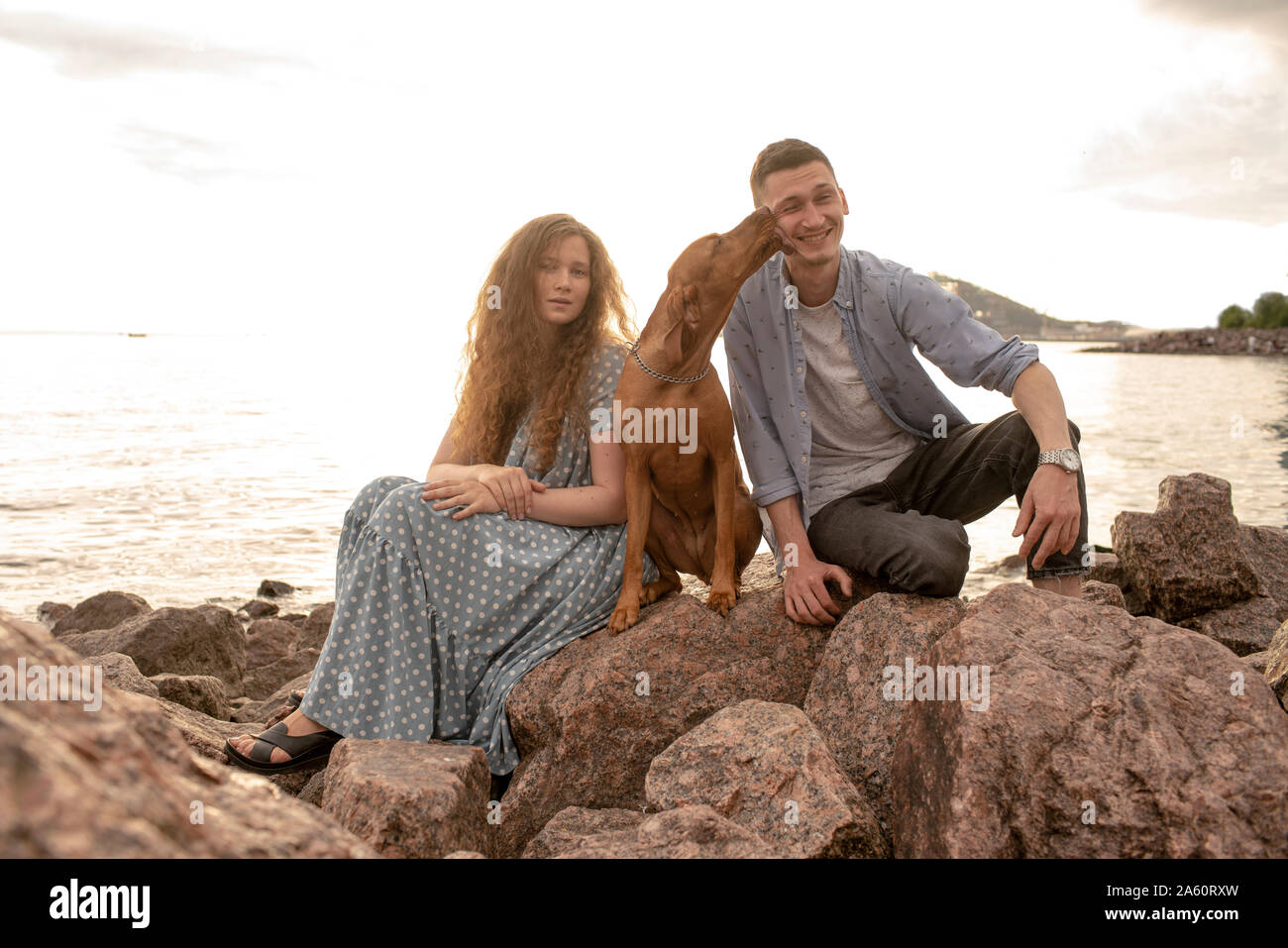Young couple with dog at the beach Stock Photo