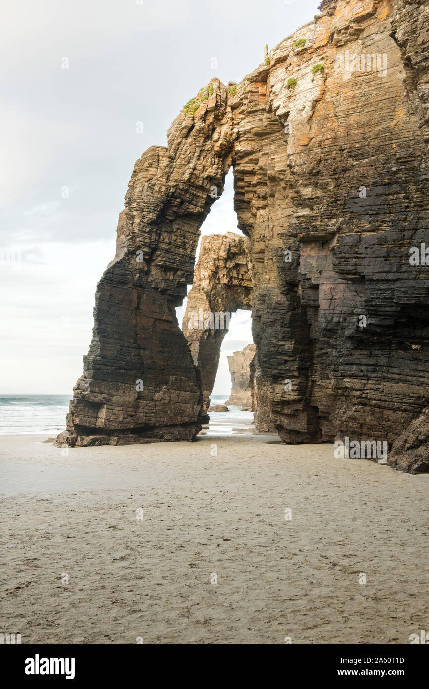 Spain, Galicia, Rock arches on Cathedrals Beach at sunset Stock Photo