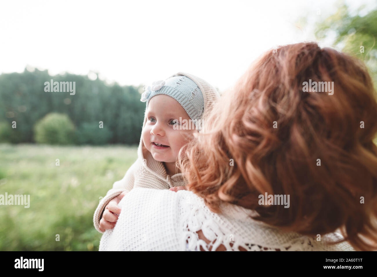 Happy little girl looking over mother's shoulder Stock Photo