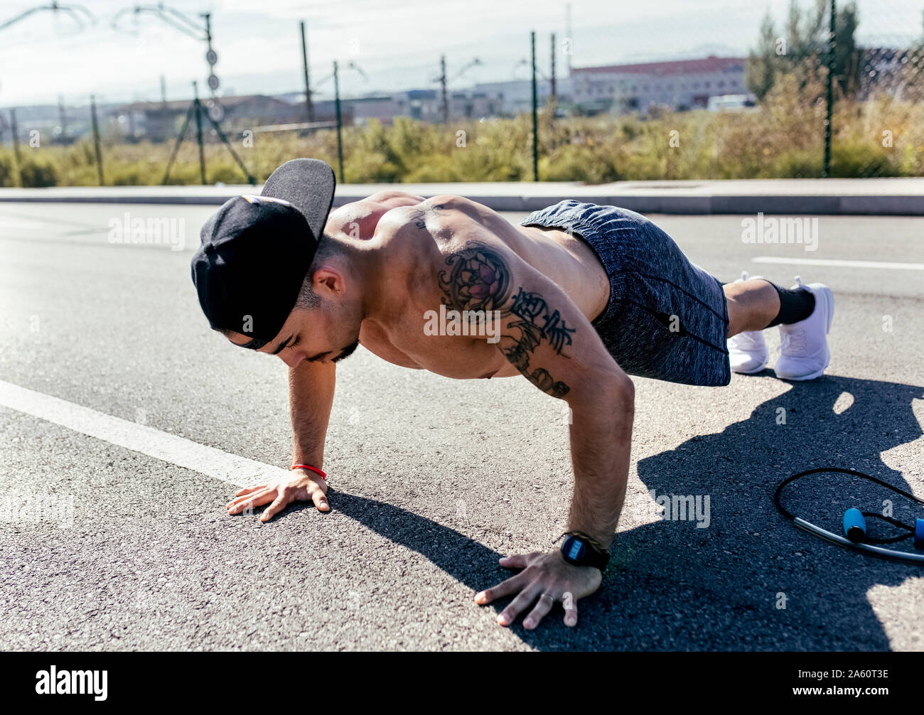Young man doing push ups on a road Stock Photo