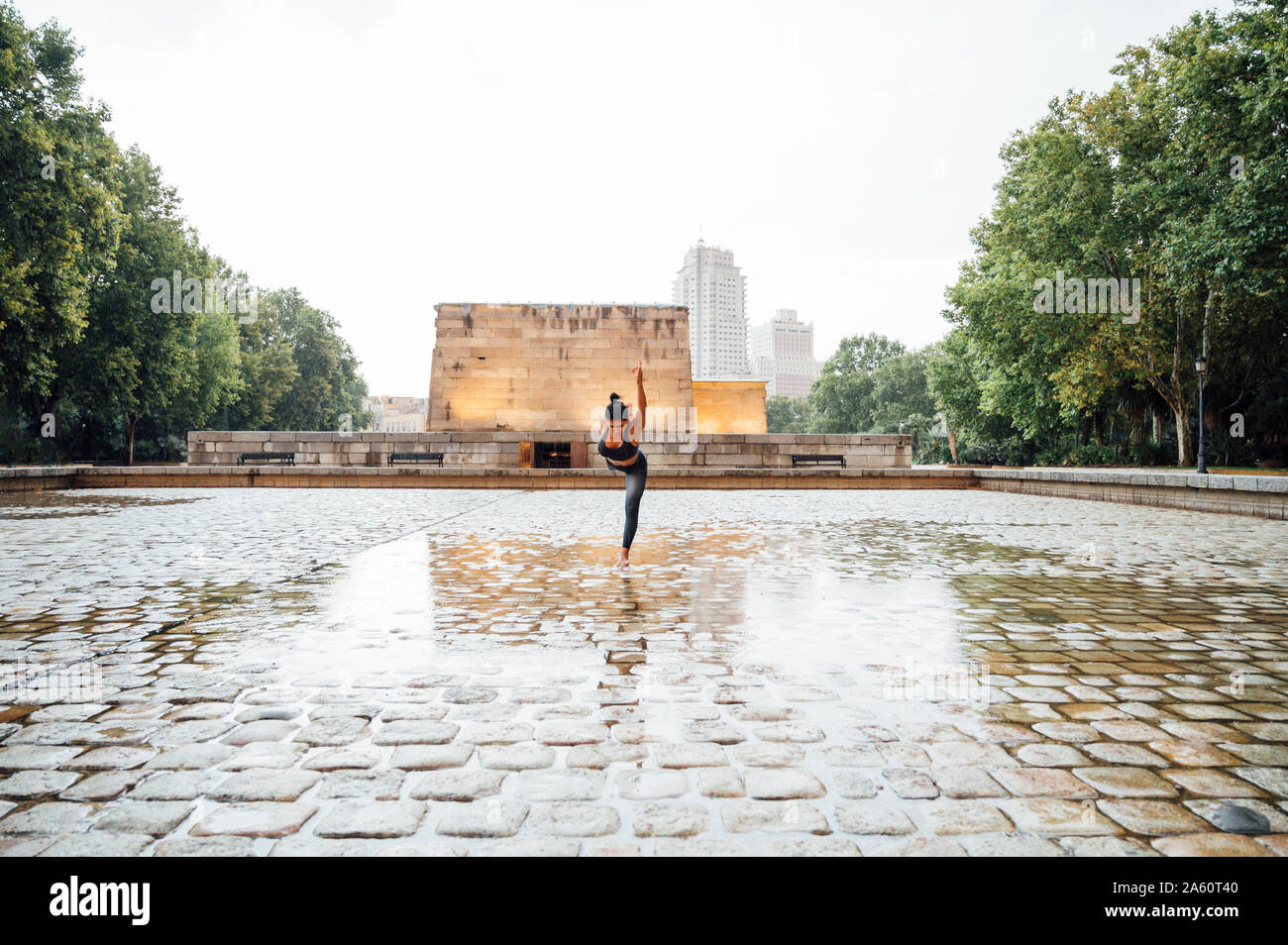Woman practicing yoga in the rain, dancer position Stock Photo