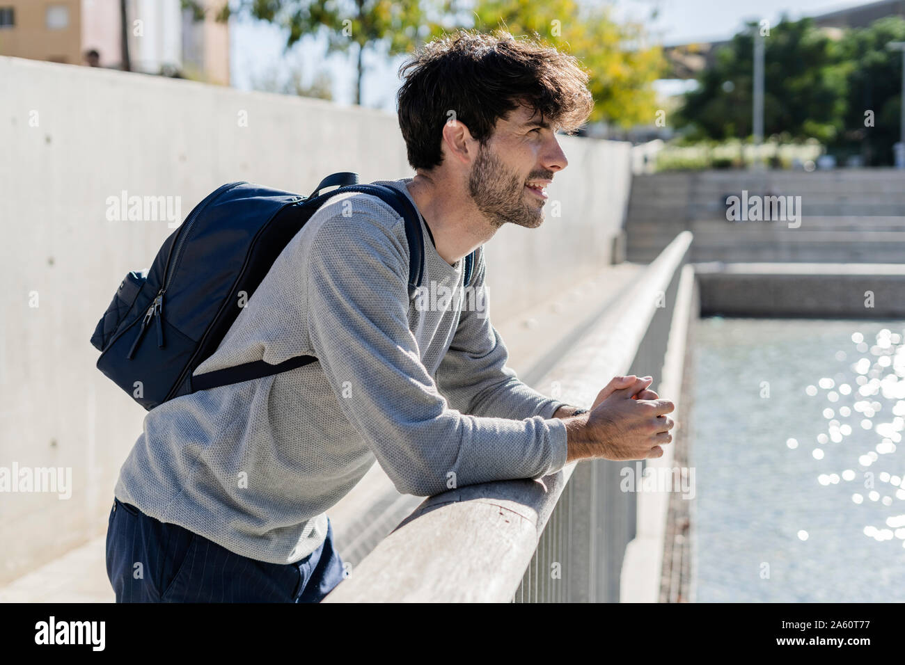 Man with backpack having a break in the city Stock Photo